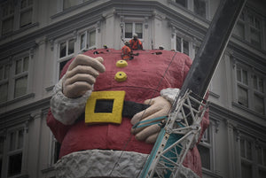 Auckland Santa. Scaffolders guiding Santas head into position